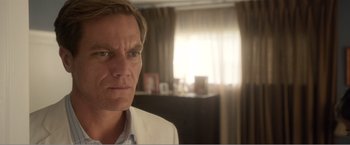 Movie still from “99 Homes” (2014), directed by Ramin Bahrani – A person wearing a suit and tie; Close Up shot, Over the shoulder angle