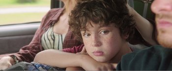 Movie still from “99 Homes” (2014), directed by Ramin Bahrani – A person with curly hair; Close Up shot, High angle