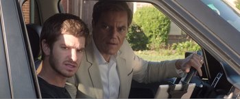 Movie still from “99 Homes” (2014), directed by Ramin Bahrani – Two men in a car looking at a cell phone; Close Up shot, Over the shoulder angle