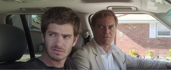 Movie still from “99 Homes” (2014), directed by Ramin Bahrani – Two men sitting in the back seat of a car; Close Up shot, Over the shoulder angle
