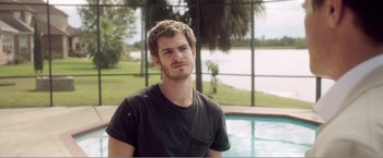Movie still from “99 Homes” (2014), directed by Ramin Bahrani – A man standing in front of a swimming pool; Close Up shot, Over the shoulder angle
