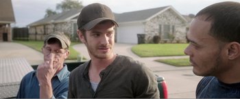 Movie still from “99 Homes” (2014), directed by Ramin Bahrani – A person wearing a hat; Close Up shot, Over the shoulder angle