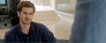 Movie still from “99 Homes” (2014), directed by Ramin Bahrani – A man sitting on the ground in a room; Close Up shot, Over the shoulder angle