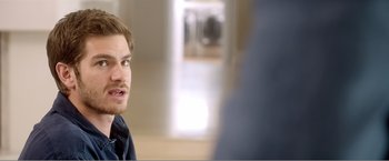 Movie still from “99 Homes” (2014), directed by Ramin Bahrani – A man with a beard is looking at the camera; Close Up shot, Over the shoulder angle