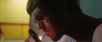 Movie still from “99 Homes” (2014), directed by Ramin Bahrani – A person lighting a cigarette; Extreme Close Up shot, Low angle
