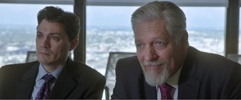 Movie still from “99 Homes” (2014), directed by Ramin Bahrani – A person wearing a suit and tie; Close Up shot, Over the shoulder angle