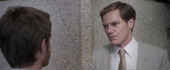 Movie still from “99 Homes” (2014), directed by Ramin Bahrani – A man wearing a suit and tie talking to another man wearing a suit and tie; Close Up shot, Over the shoulder angle