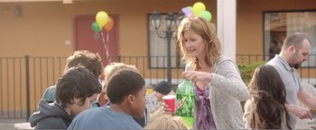 Movie still from “99 Homes” (2014), directed by Ramin Bahrani – A group of people sitting around a table with drinks; Medium shot, Over the shoulder angle