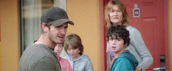 Movie still from “99 Homes” (2014), directed by Ramin Bahrani – A group of people standing next to each other in front of a building; Close Up shot, Over the shoulder angle