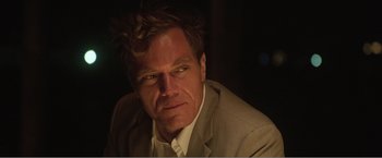 Movie still from “99 Homes” (2014), directed by Ramin Bahrani – A person wearing a suit and tie; Close Up shot, Over the shoulder angle