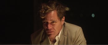 Movie still from “99 Homes” (2014), directed by Ramin Bahrani – A person wearing a suit and tie; Close Up shot, Low angle