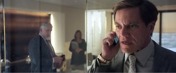 Movie still from “99 Homes” (2014), directed by Ramin Bahrani – A man talking on a cell phone in front of a mirror; Close Up shot, Over the shoulder angle