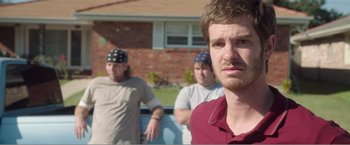 Movie still from “99 Homes” (2014), directed by Ramin Bahrani – Three men standing in front of a brick house; Close Up shot, Over the shoulder angle