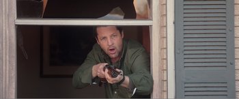 Movie still from “99 Homes” (2014), directed by Ramin Bahrani – A man holding a gun in his hand; Medium shot, Low angle