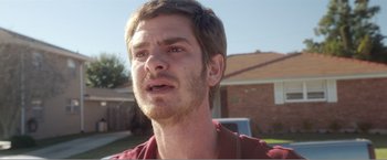Movie still from “99 Homes” (2014), directed by Ramin Bahrani – A person with a beard; Close Up shot, Over the shoulder angle