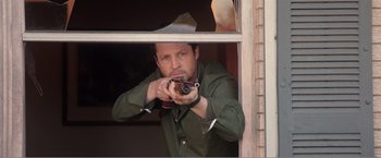 Movie still from “99 Homes” (2014), directed by Ramin Bahrani – A man is holding a gun in his hand; Medium shot, Over the shoulder angle