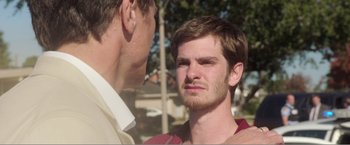 Movie still from “99 Homes” (2014), directed by Ramin Bahrani – A man with a goatee is talking to another man; Close Up shot, Over the shoulder angle