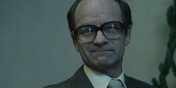 Movie still from “Chernobyl” (2019), directed by Johan Renck – An older man wearing a suit and glasses; Close Up shot, Over the shoulder angle