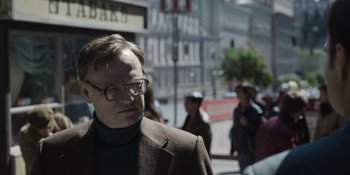 Movie still from “Chernobyl” (2019), directed by Johan Renck – A man wearing glasses and a brown suit jacket; Close Up shot, Over the shoulder angle
