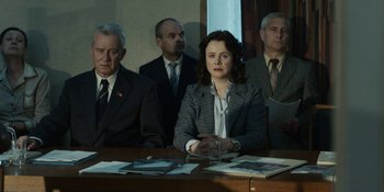 Movie still from “Chernobyl” (2019), directed by Johan Renck – A group of people sitting around a table; Medium shot, Low angle
