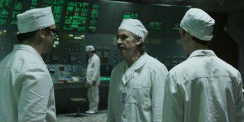 Movie still from “Chernobyl” (2019), directed by Johan Renck – A group of men in white lab coats and white hats; Medium shot, Low angle