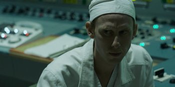 Movie still from “Chernobyl” (2019), directed by Johan Renck – A man wearing a white robe and a white hat; Close Up shot, Over the shoulder angle