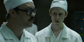 Movie still from “Chernobyl” (2019), directed by Johan Renck – Two men in white lab coats looking at each other in front of a mirror; Close Up shot, Over the shoulder angle