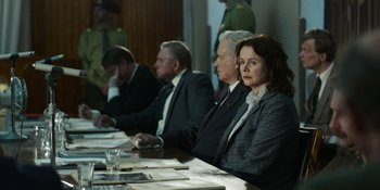 Movie still from “Chernobyl” (2019), directed by Johan Renck – A group of people sitting around a table; Medium shot, Over the shoulder angle