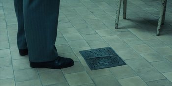 Movie still from “Chernobyl” (2019), directed by Johan Renck – A man standing next to a metal grate; Extreme Close Up shot, High angle