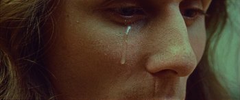 Movie still from “Jacques - Absolve” (2023), directed by Paul Trillo – Extreme Close Up shot, High angle