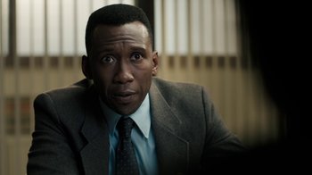 Movie still from “True Detective” (2014), created by Issa López – A person wearing a suit and tie; Close Up shot, Over the shoulder angle