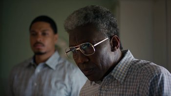 Movie still from “True Detective” (2014), created by Issa López – A man wearing glasses and a checkered shirt; Close Up shot, Over the shoulder angle