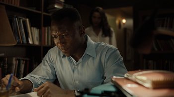 Movie still from “True Detective” (2014), created by Issa López – A man sitting at a table writing on a piece of paper; Close Up shot, Over the shoulder angle