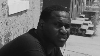 Movie still from “Jurdan Bryant - Words for Thomas” (2019), directed by Alonzo Hellerbach – Close Up shot, Low angle