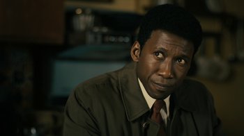 Movie still from “True Detective” (2014), created by Issa López – A person wearing a suit and tie; Close Up shot, Over the shoulder angle