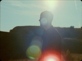 Movie still from “James Blake feat. Rosalía - Barefoot In The Park” (2019), directed by Diana Kunst – Medium shot, Low angle