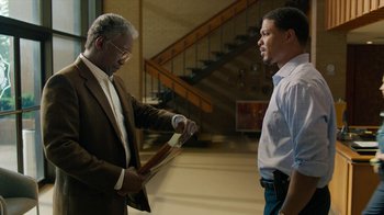 Movie still from “True Detective” (2014), created by Issa López – Two men standing next to each other in front of a staircase; Medium shot, Over the shoulder angle