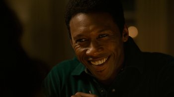 Movie still from “True Detective” (2014), created by Issa López – A person with a smile on their face; Close Up shot, Over the shoulder angle