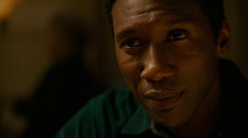 Movie still from “True Detective” (2014), created by Issa López – A man's face in a green shirt; Close Up shot, Over the shoulder angle