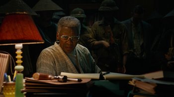 Movie still from “True Detective” (2014), created by Issa López – An older man sitting at a table with a pen and paper; Close Up shot, High angle