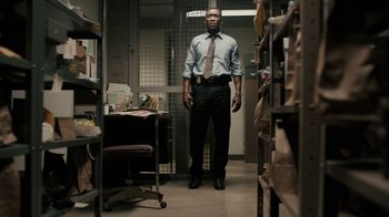 Movie still from “True Detective” (2014), created by Issa López – A man standing in a jail cell with his hands on his hips; Medium shot, Low angle