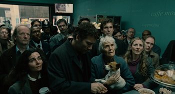 Movie still from “Children of Men” (2006), directed by Alfonso Cuarón – A man holding a dog in front of a crowd of onlookers; Medium shot, Over the shoulder angle