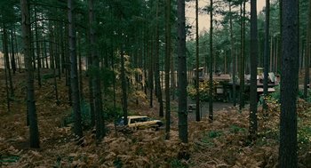 Movie still from “Children of Men” (2006), directed by Alfonso Cuarón – A yellow truck parked in the middle of a forest; Extreme Wide shot, High angle