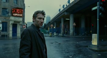 Movie still from “Children of Men” (2006), directed by Alfonso Cuarón – A man standing in the middle of a street; Medium shot, Low angle