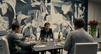 Movie still from “Children of Men” (2006), directed by Alfonso Cuarón – A group of people sitting around a table with wine glasses; Medium shot, Over the shoulder angle