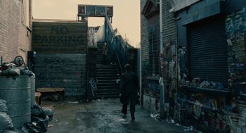 Movie still from “Children of Men” (2006), directed by Alfonso Cuarón – A man walking down the side of a street; Extreme Wide shot, High angle