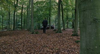 Movie still from “Children of Men” (2006), directed by Alfonso Cuarón – A man standing in the middle of a forest; Extreme Wide shot, High angle