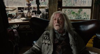 Movie still from “Children of Men” (2006), directed by Alfonso Cuarón – An old man with long white hair wearing glasses; Medium shot, Over the shoulder angle