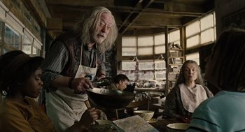 Movie still from “Children of Men” (2006), directed by Alfonso Cuarón – An old man is cooking food in a kitchen; Medium shot, Over the shoulder angle