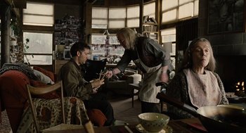 Movie still from “Children of Men” (2006), directed by Alfonso Cuarón – A man and a woman in a room with chairs and a table; Medium shot, Over the shoulder angle